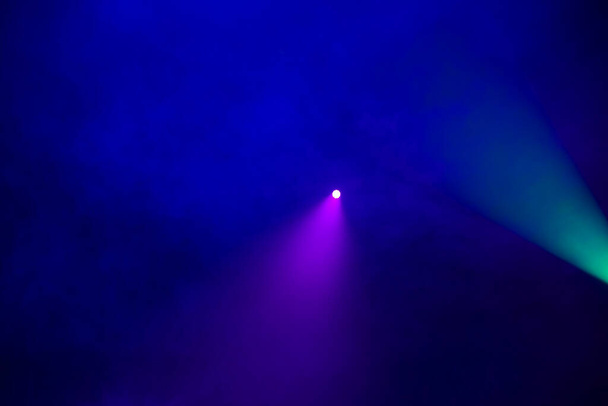 Green and purple light beam on a dark blue smoky background. - Photo, Image