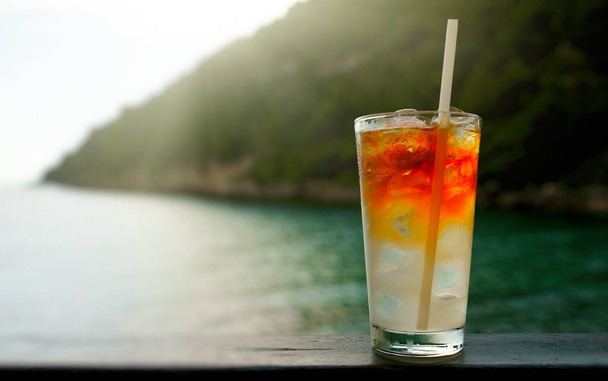 Glass of Mai Tai cocktail in front of the sea background. - Photo, image