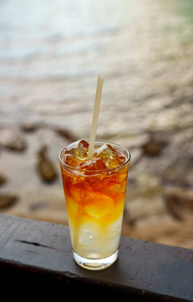 Glass of Mai Tai cocktail in front of the sea background. - Foto, Imagen