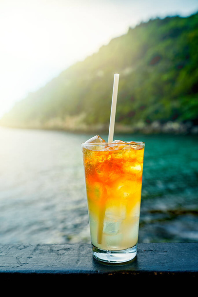 Szklanka koktajlu Mai Tai przed tłem morza. - Zdjęcie, obraz
