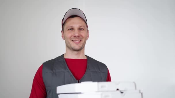 Pizza delivery. Courier passing white cardboard pizza box against white background. - Séquence, vidéo