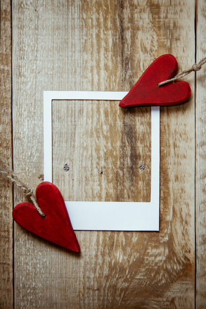 Kaksi punaista sydämen muotoinen Ystävänpäivä on maalaismainen puinen tausta polaroid runko
 - Valokuva, kuva