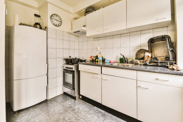 een keuken met witte kasten en zwarte aanrechtbladen op de aanrechtbladen op deze foto is van binnenuit genomen - Foto, afbeelding