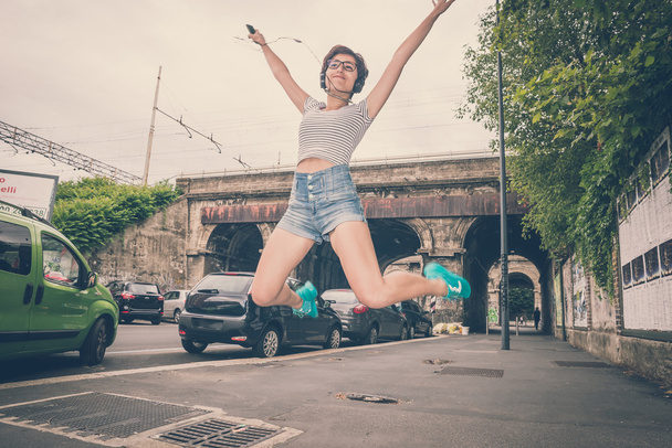 joven hipster mujer escuchando música saltar
 - Foto, Imagen