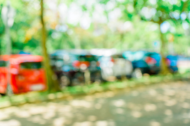 Defocused abstract background of a car park area surrounded by trees. Blurred out park area background - Foto, Imagen