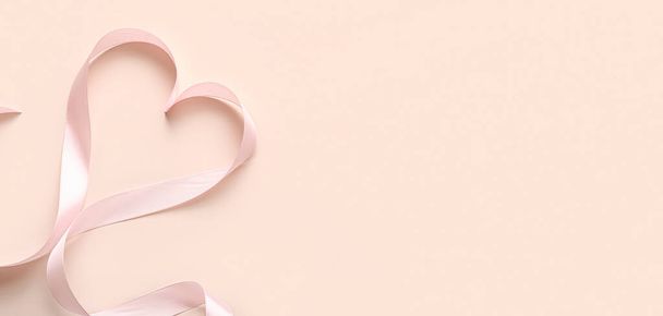 Καρδιά από ροζ κορδέλα σε μπεζ φόντο με χώρο για κείμενο. Γιορτή του Αγίου Βαλεντίνου - Φωτογραφία, εικόνα