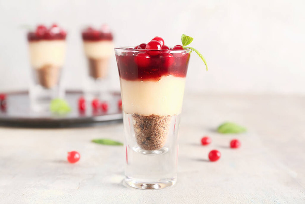 Shot of delicious pudding with cranberry, mint and jam on light table - Foto, afbeelding