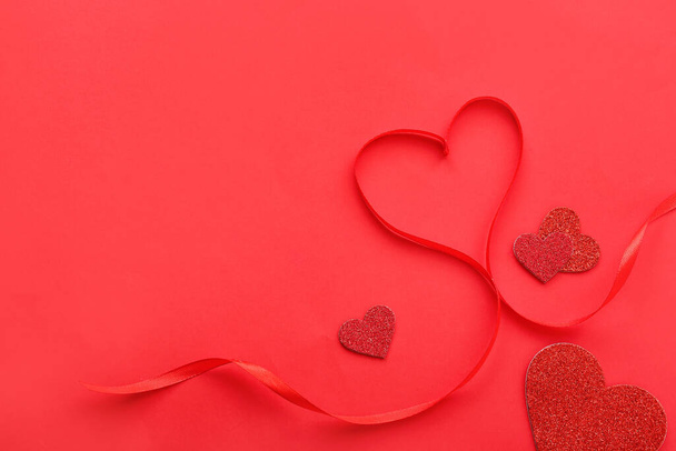 Ribbon with hearts on red background. Valentine's Day celebration - Fotoğraf, Görsel