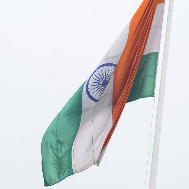 India flag flying high at Connaught Place with pride in blue sky, India flag fluttering, Indian Flag on Independence Day and Republic Day of India, tilt up shot, Waving Indian flag, Har Ghar Tiranga - Foto, afbeelding