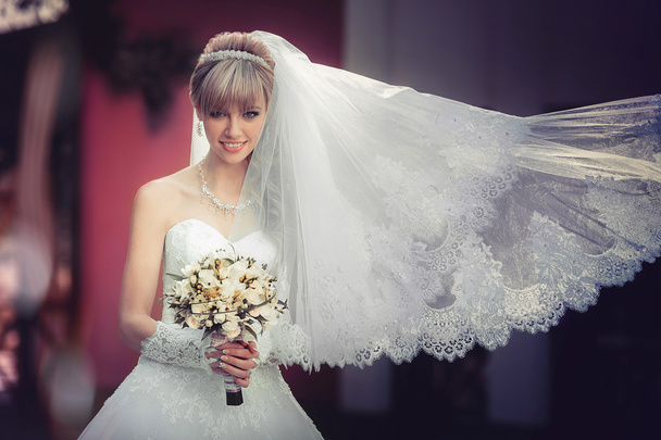 Πορτρέτο του μια όμορφη ξανθιά νύφη με γαμήλια ανθοδέσμη - Φωτογραφία, εικόνα