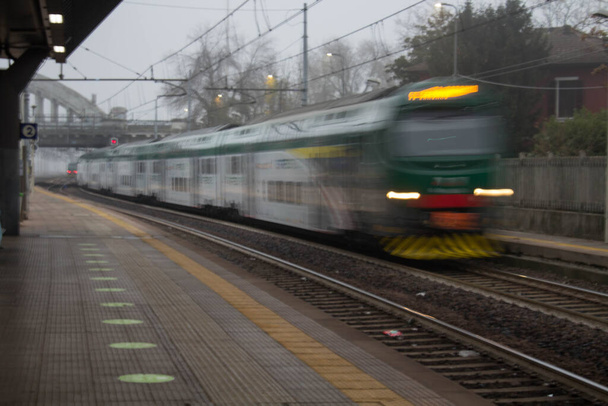 sugestywny obraz pociągu przejeżdżającego przez włoską stację w zły dzień - Zdjęcie, obraz