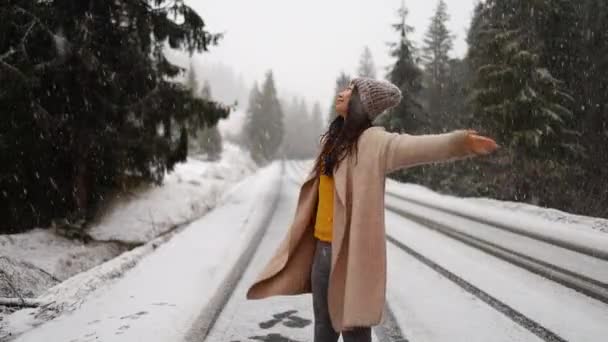 Šťastný mladý asijské žena walking v zimní přírodě pod padajícím sněhem. - Záběry, video