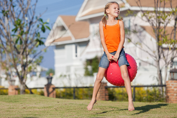 happy girl playing with inflatable balls on the lawn - Фото, зображення