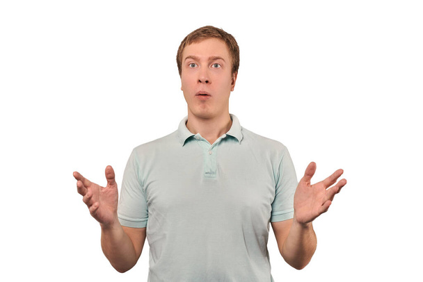 Confused young guy shrugged shoulders, guy in mint casual T-shirt spread arms, isolated on white background. Puzzled young man spread his hands, bewildered don't know gesture - Foto, imagen