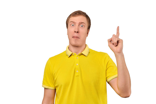 Funny young guy in yellow T-shirt with eureka gesture, man got idea, isolated on white background. Surprised man pointing index finger up, found solution to work task, remembered forgotten thought - Fotografie, Obrázek