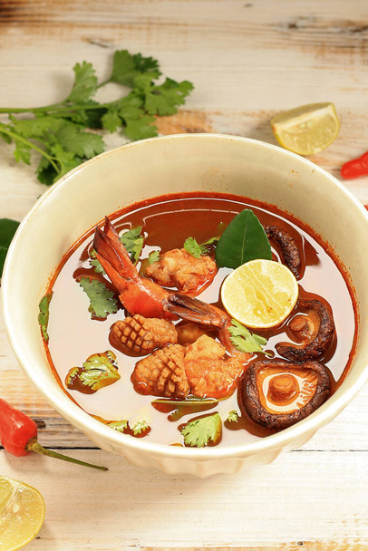 Tom Yum Kung Thai Hot Spicy Soup Shrimp with Lemongrass, Lemon, Galangal,  and Chilli on White Wooden Background. Thailand Food - Foto, Imagem