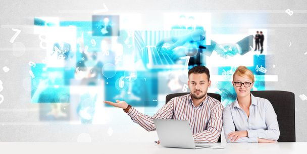 Business persons at desk with modern tech images at background - Photo, image