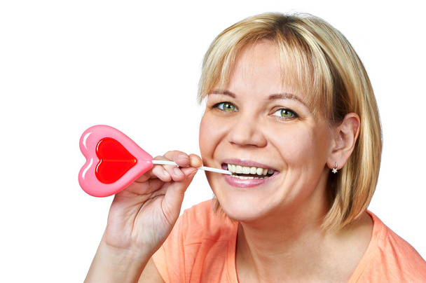 Happy girl with heart shaped lollipop - Photo, Image