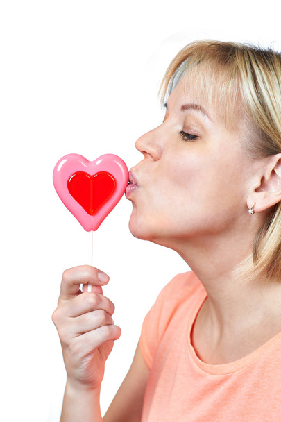 Happy girl kissing heart shaped lollipop - Φωτογραφία, εικόνα