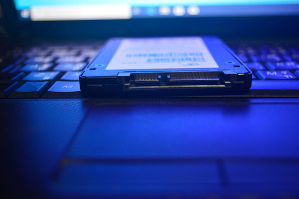 SSD drives zijn erg populair deze dagen, SSD 's worden geplaatst op laptops (deze foto was bedoeld om donker te kijken en blauw licht te gebruiken). - Foto, afbeelding