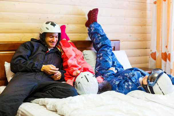 family in bed after skiing at winter resort. - Foto, Imagen