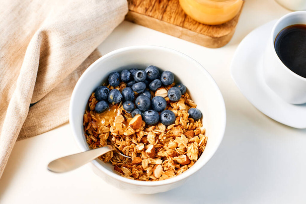 Granola with nuts and a cup of coffee for breakfast. Balanced diet for vegetarians or vegans.  - Photo, Image