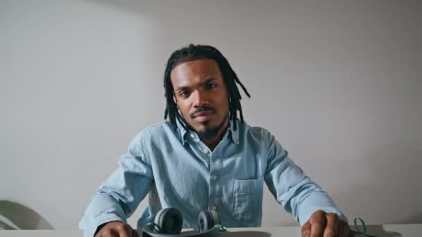 Smiling freelancer looking camera workplace portrait. Positive sound producer relaxing in apartment. Happy african american guy resting remotely closeup. Black dreadlocks person posing after work - Felvétel, videó