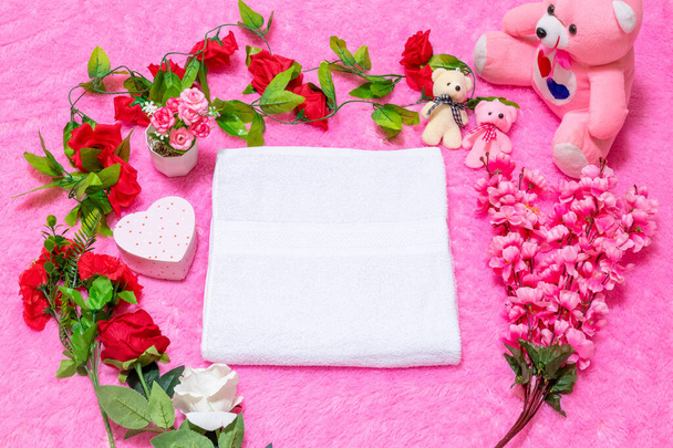 White blank towel above a fluffy pink carpet, and surrounded by valentine themed decorations - Foto, imagen