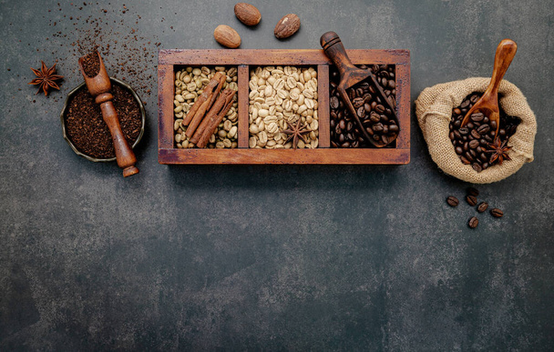 grains de café torréfiés avec de la poudre de café et des ingrédients savoureux pour faire une configuration de café savoureux sur fond de pierre sombre. - Photo, image