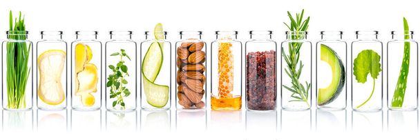 Homemade skin care with natural ingredients avocado ,aloe vera ,cucumber ,himalayan salt  ,honeycomb ,almonds ,centella asiatica, ginger slice and rosemary  in glass bottles isolate on white background. - Photo, image