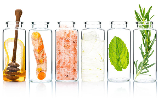 The glass bottle of homemade skin care and body scrubs with natural ingredients aloe vera ,himalayan salt ,peppermint ,rosemary ,turmeric and honey isolate on white background. - Photo, image