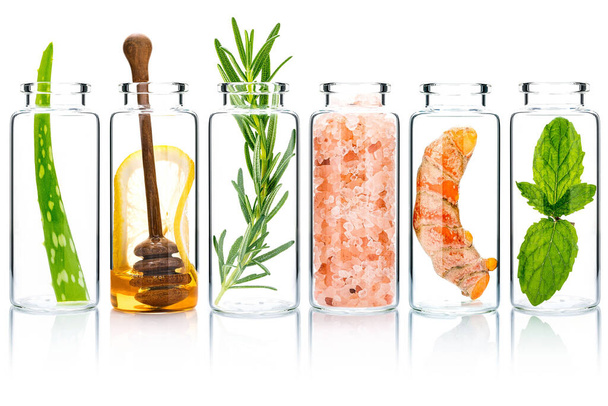 The glass bottle of homemade skin care and body scrubs with natural ingredients aloe vera ,himalayan salt ,peppermint ,rosemary ,turmeric and honey isolate on white background. - Photo, image