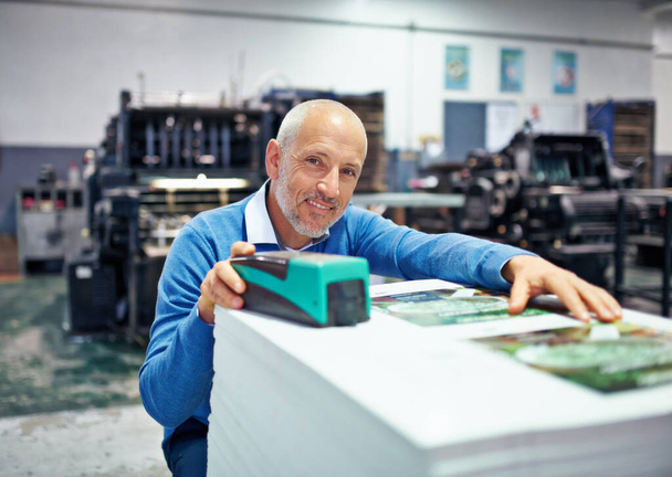 I always have the final say. Portrait of a man checking the quality of a print run in a factory - Photo, Image
