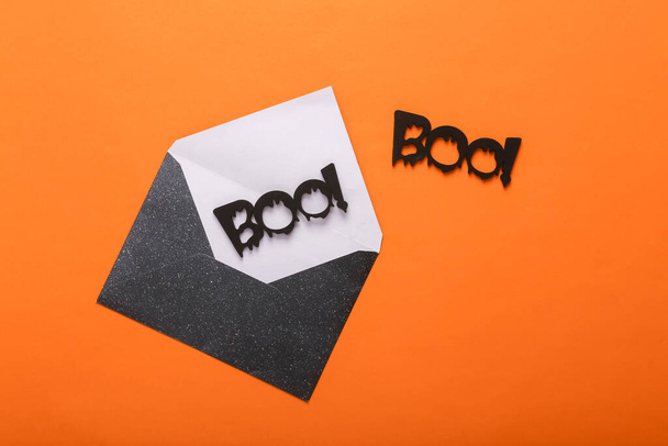 Halloween envelop met woorden boo! op oranje achtergrond. Bovenaanzicht. Vlakke plaat - Foto, afbeelding