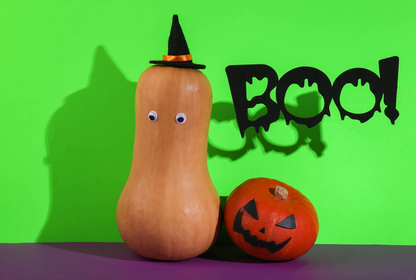 Zucche di Halloween con la parola boo! su sfondo viola verde. Layout creativo di Halloween. Natura morta minima - Foto, immagini