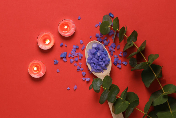 Kylpylät, aromaterapia. Laventelikylpy suola aromikynttilöillä ja eukalyptuksen oksalla punaisella pohjalla - Valokuva, kuva