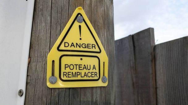 niebezpieczeństwo poteau znak remplacer tekst francuski oznacza niebezpieczeństwo i słup do wymiany w drewnianym słupie telefonicznym elektrycznym - Zdjęcie, obraz