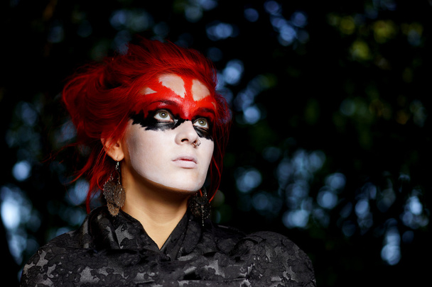 Woman with red hairs and black make-up mask - Foto, afbeelding
