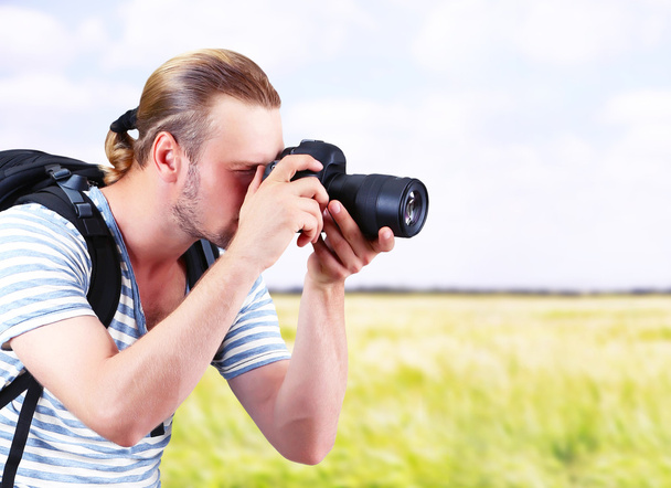 Young photographer taking photos outdoors - Fotó, kép