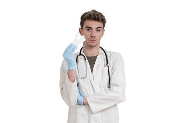 Junger kaukasischer Arzt mit negativem Covid-19-Antigen-Test. Isoliert über weißem Hintergrund. - Foto, Bild
