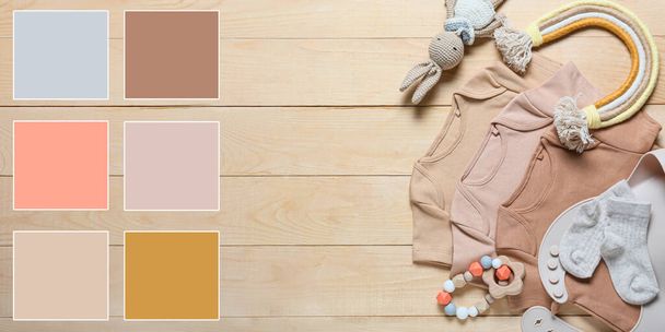 Stylish baby clothes and toys on wooden background. Different color patterns - Foto, imagen
