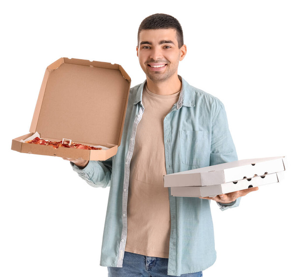 Komea nuori mies tilalla laatikot tuoretta pizzaa valkoisella taustalla - Valokuva, kuva