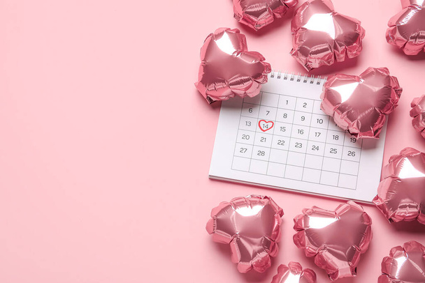 Calendar with marked date of Valentine's Day and balloons on pink background - Foto, Imagem