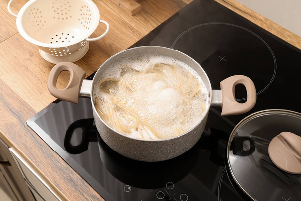 Μαγειρική κατσαρόλα με βραστό ζυμαρικά στην ηλεκτρική κουζίνα - Φωτογραφία, εικόνα