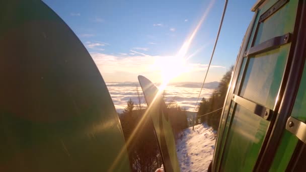 CLOSE UP: Picturesque ride with cable car from ski resort down to misty valley. Wonderful view during the descent from mountain after a day of winter sports activities on snow at alpine ski resort. - Filmagem, Vídeo