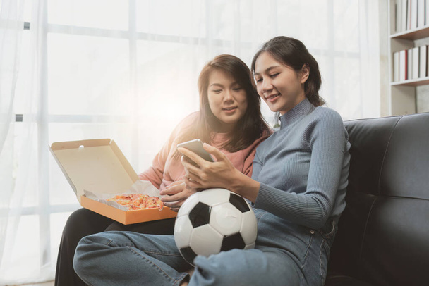 Excited friends having fun by watching football or soccer match and eating pizza at home. Friendship, leisure, rest, home party football, Soccer concept. - Photo, Image