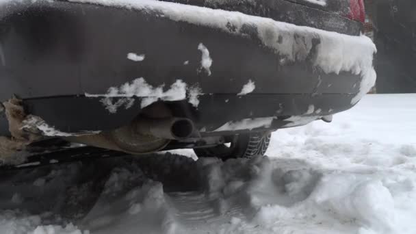 Smoke comes from exhaust pipe of car against background of snow or winter. Concept of greenhouse effect and climate warming. Emission of carbon dioxide and heavy metals into otmosphere. - Felvétel, videó