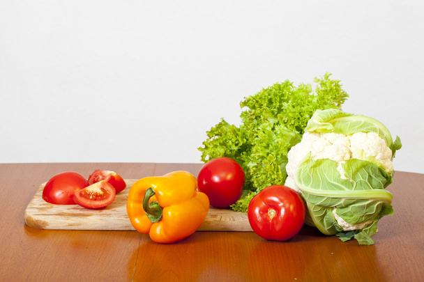 Still-life from fresh salad, a tomato, pepper and a cauliflower - Foto, afbeelding
