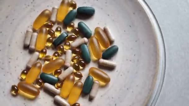 Spinning many big vitamin d, spirulina, omega 3, iron, pills close up. Medicine. Static frame. Rotating on gray plate - Video