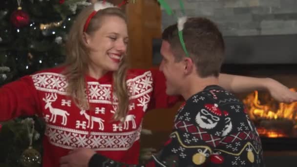 CLOSE UP: Happy grateful woman hugging her husband after receiving Christmas present. Young couple celebrates winter holidays in a beautifully decorated home and exchanges gifts on the festive evening - Filmati, video